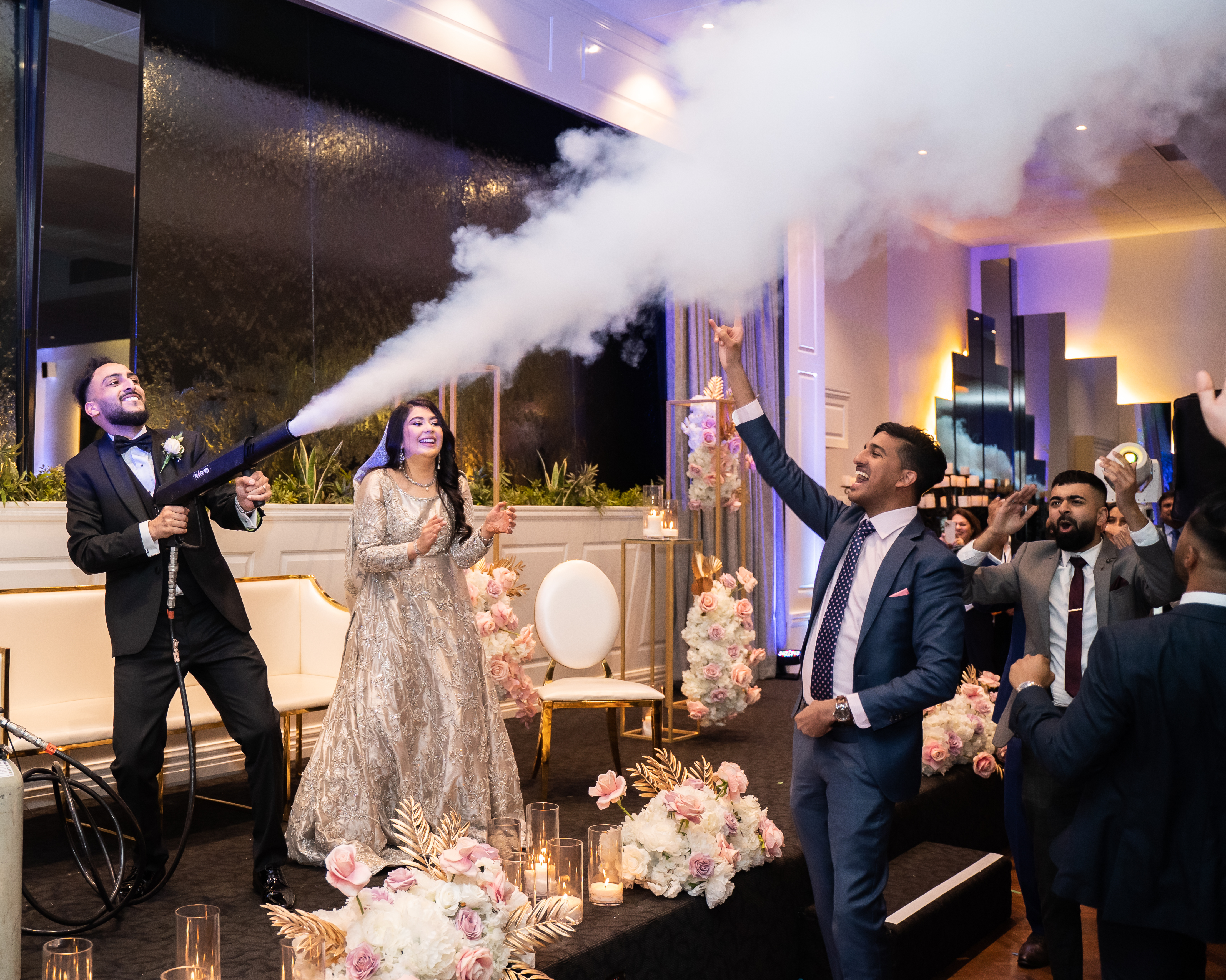 Couple and guests celebrating with a handheld smoke effect at their reception