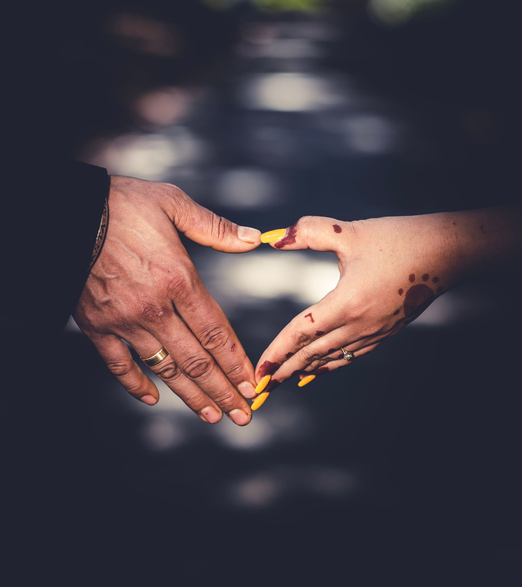 Wedding couple forming a heart with their hands and wedding rings