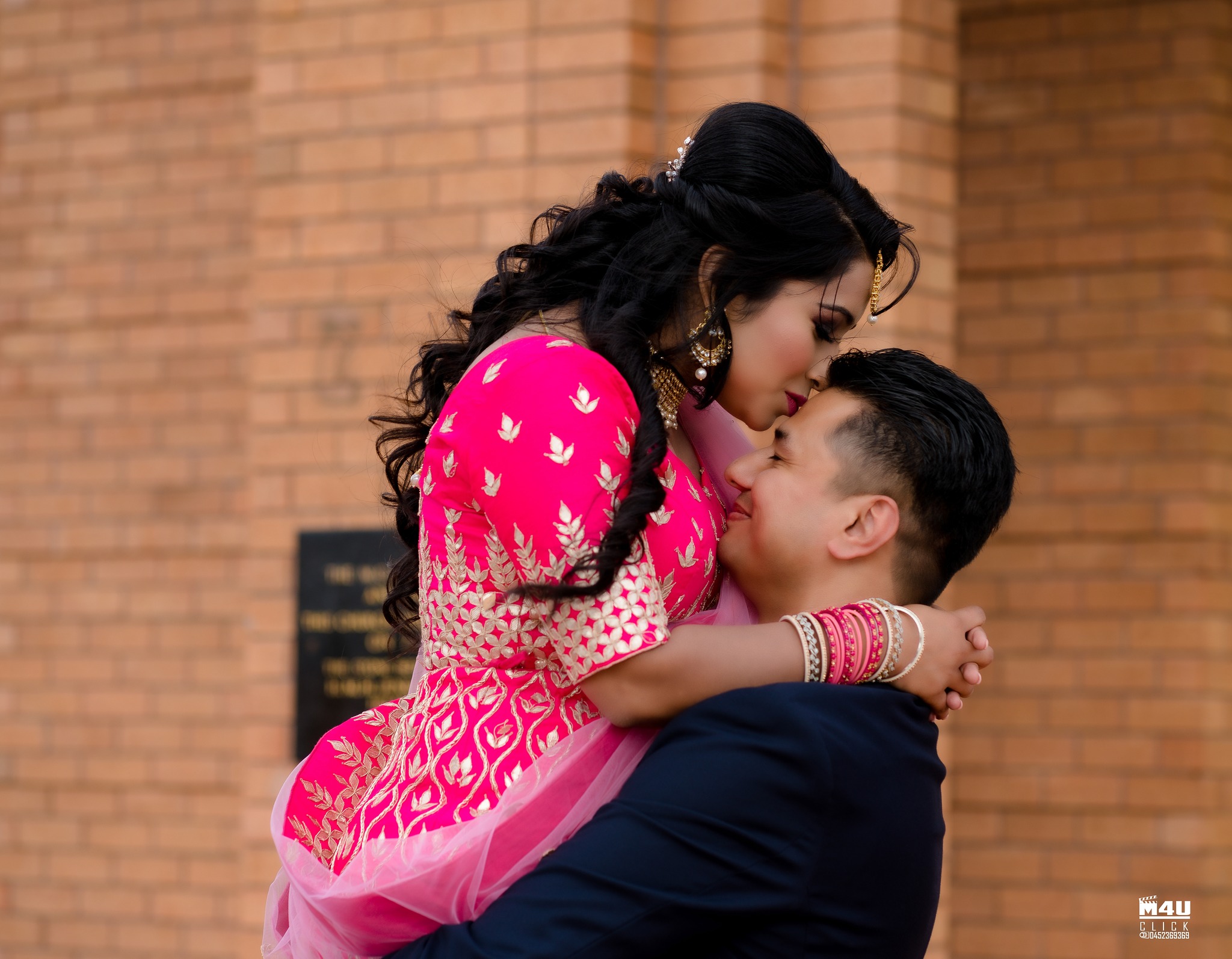 Bride in pink embracing the groom outdoors