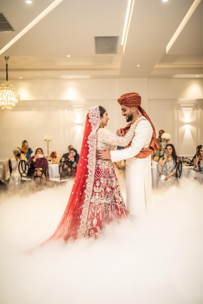Couple sharing their first dance surrounded by low-lying dry ice clouds