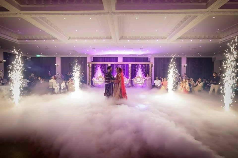 Wide view of a first dance with cold sparks and dry ice across the dance floor
